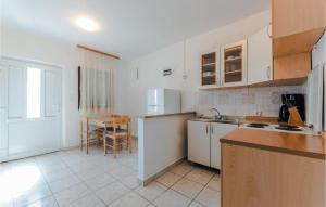 una cucina con armadi bianchi e un tavolo di 2 Bedroom Gorgeous Apartment In Bosana a Stan Trigraci