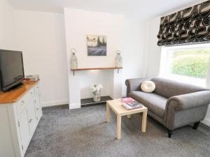 un salon avec un canapé et une télévision dans l'établissement Bluebell Cottage, à Selby