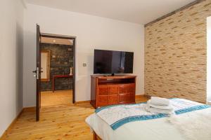 a bedroom with a bed and a flat screen tv at Deluxe Apartment in Lanark