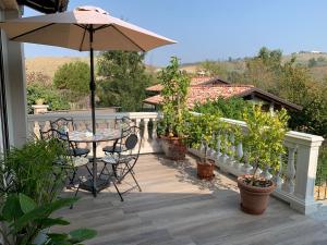 a patio with an umbrella and a table and chairs at B&B Casa Favari in Montalbo