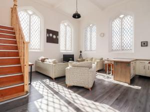 a large living room with a staircase and a table at Asquith Penthouse in Huddersfield