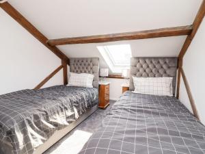 - une chambre mansardée avec 2 lits et une fenêtre dans l'établissement Asquith Penthouse, à Huddersfield