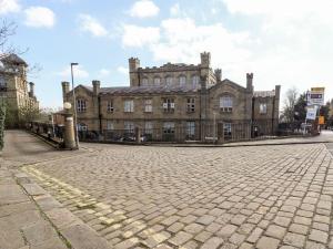 an old building with a cobblestone street in front of it at Asquith Penthouse in Huddersfield