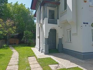 a white house with a door and a yard at Villa Maria De Luxe in Bucharest