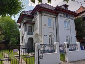 uma casa branca com uma cerca à frente. em Villa Maria De Luxe em Bucareste