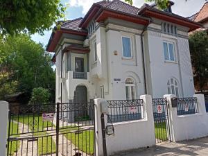 a white house with a fence in front of it at Villa Maria De Luxe in Bucharest
