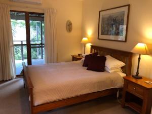 a bedroom with a bed with two lamps and a window at Meriba B and B in Bundanoon