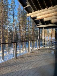 una terraza de madera con vistas al bosque en Levi Ski IN Ski OUT Premium VillaWestWind B en Levi