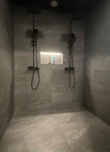 a bathroom with a shower with two lights on the wall at Levi Ski IN Ski OUT Premium VillaWestWind B in Levi