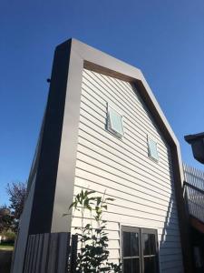 ein weißes Haus mit zwei seitlichen Fenstern in der Unterkunft Limeburners Loft Geelong - Walk to CBD Waterfront Hospitals in Thomson
