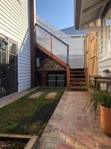 a patio with a wooden stairway next to a house at Limeburners Loft Geelong - Walk to CBD Waterfront Hospitals in Thomson