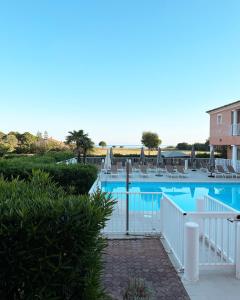 una piscina con sedie a sdraio e un resort di Hôtel Thalassa a Saint-Florent