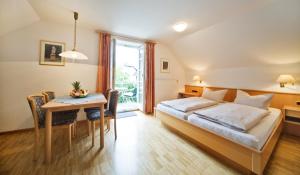 pokój hotelowy z łóżkiem i stołem w obiekcie Warsberger Weinhof - Hotel & Weinwirtschaft w mieście Neumagen-Dhron
