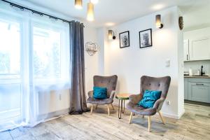 two chairs and a table in a room with a window at Apartament Dla Dwojga in Sanok