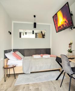 a bedroom with a bed and a tv on the wall at Apartament Dla Dwojga in Sanok