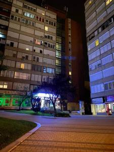 una calle vacía delante de un edificio por la noche en Dózsa Apartman en Gödöllő