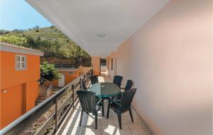 einen Balkon mit einem Tisch und Stühlen darauf in der Unterkunft Gorgeous Apartment In Bosana With Kitchen in Stan Trigraci