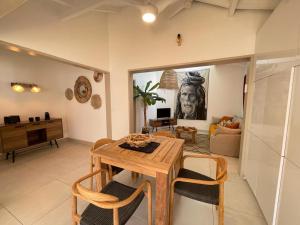 a living room with a wooden table and chairs at Wahoo lodge, piscine privée, orient bay in Orient Bay