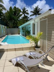 a swimming pool with a white chair and a swimming pool at Wahoo lodge, piscine privée, orient bay in Orient Bay French St Martin