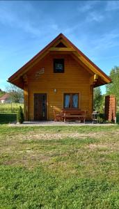 a log cabin with a bench in front of it at Słoneczne Zacisze in Smołdziński Las