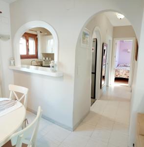 cocina blanca con arco y mesa en Villa totalmente independiente con piscina comunitaria, en Calpe