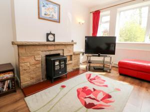 a living room with a fireplace and a tv at Loose Hill Lea in Bamford