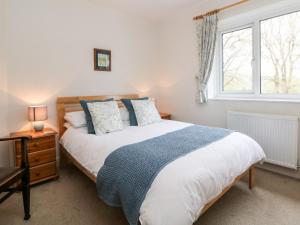 a bedroom with a large bed and a window at Loose Hill Lea in Bamford