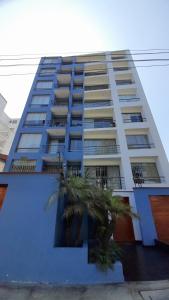 un grand bâtiment avec des palmiers devant lui dans l'établissement Apartment 4 Rent - Av San Borja Norte Cdra 8, à Lima