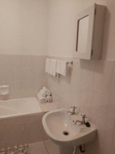 uma casa de banho branca com um lavatório e uma banheira em Unit 24 Pendleberry Grove Holidays em Bela-Bela