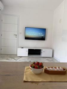 a living room with a bowl of fruit and a tv at Apartman Žepče in Žepče