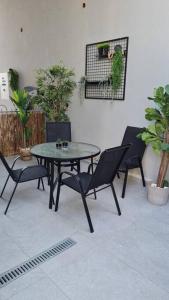a table and chairs in a room with plants at הבית של כנרת in H̱efẕi Bah