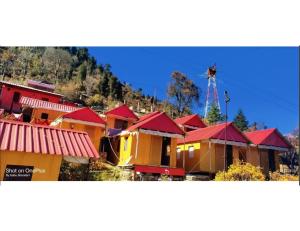 a group of houses with red roofs and a windmill at Shivalik Camping & Cottage, Joshimath in Joshīmath