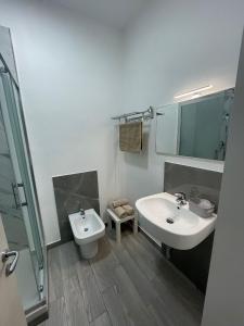 a white bathroom with a sink and a toilet at Le Camere Del Villaggio in Agrigento