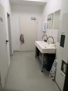 a white bathroom with a sink and a mirror at Gästehaus Maria Rast in Suderburg