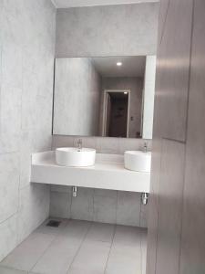 a bathroom with two sinks and a mirror at Seaview Bliss Studio By Tropical Elegance in Kota Kinabalu