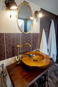 La salle de bains est pourvue d'un lavabo en bois et d'un miroir. dans l'établissement Stairs to Heaven, à Ventspils