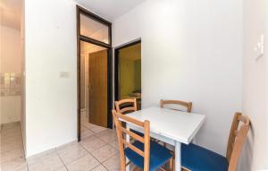 a dining room with a white table and chairs at Cozy Apartment In Bosana With Kitchen in Stan Trigraci