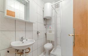 a white bathroom with a toilet and a sink at Cozy Apartment In Bosana With Kitchen in Stan Trigraci