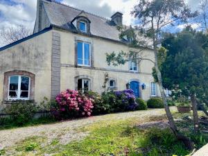 una casa vieja con flores delante en La Ptite Normande, en Saint-Germain-de-Tournebut