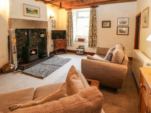a living room with a couch and a fireplace at Arklehurst in Low Eskcleth