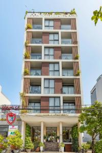 a tall apartment building with plants on it at Moon Hotel and Apartment Da Nang in Danang