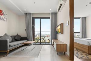 Moon Hotel and Apartment Da Nang في دا نانغ: غرفه فندقيه بسرير واريكه