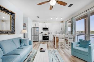 a living room with a blue couch and a kitchen at Destiny Beach Villas #15A in Destin