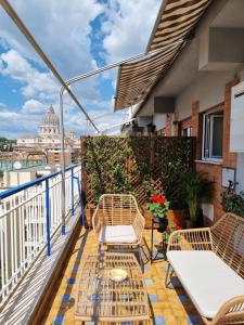 einen Balkon mit Stühlen und Tischen auf einem Gebäude in der Unterkunft Le Terrazze del Duca San Pietro Guesthouse in Rom