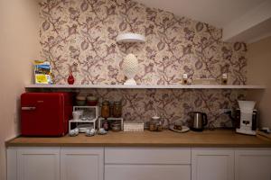 cocina con encimera y nevera roja en Il Melograno chic&nature, en Santa Maria La Carità