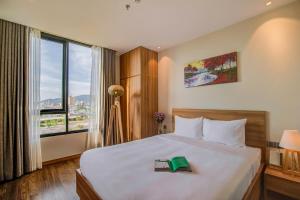Postel nebo postele na pokoji v ubytování Moon Hotel and Apartment Da Nang