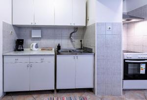 eine Küche mit weißen Schränken und einem Waschbecken in der Unterkunft Dubrovnik Heritage Apartments in Dubrovnik