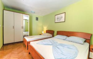 two beds in a room with green walls at Beautiful Apartment In Bosana With Wifi in Stan Trigraci