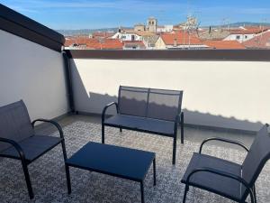 três cadeiras e uma mesa numa varanda em B&B Palazzo del Contestabile em Tróia