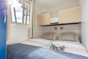 sypialnia z 2 łóżkami w małym domku w obiekcie Bungalows Tia Polly & Indiana Jones & Yoko Ono w mieście L'Escala